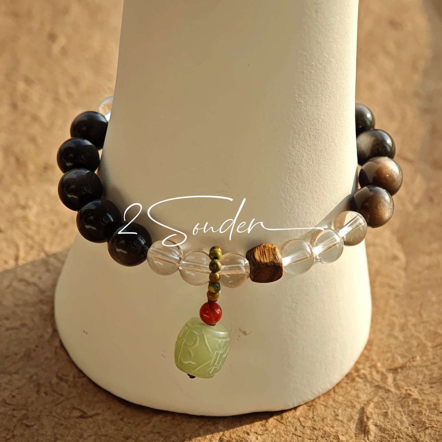 This bracelet combines genuine Silver Obsidian (look for the subtle silver sheen under light), high-clarity White Quartz, and Real Agarwood. Unlike synthetic imitations, our Agarwood carries a faint, natural woody scent that deepens over time. Plus, there is an Agate ring in the bracelet, which adds a touch of classical beauty. It feels grounded and real on your skin.
