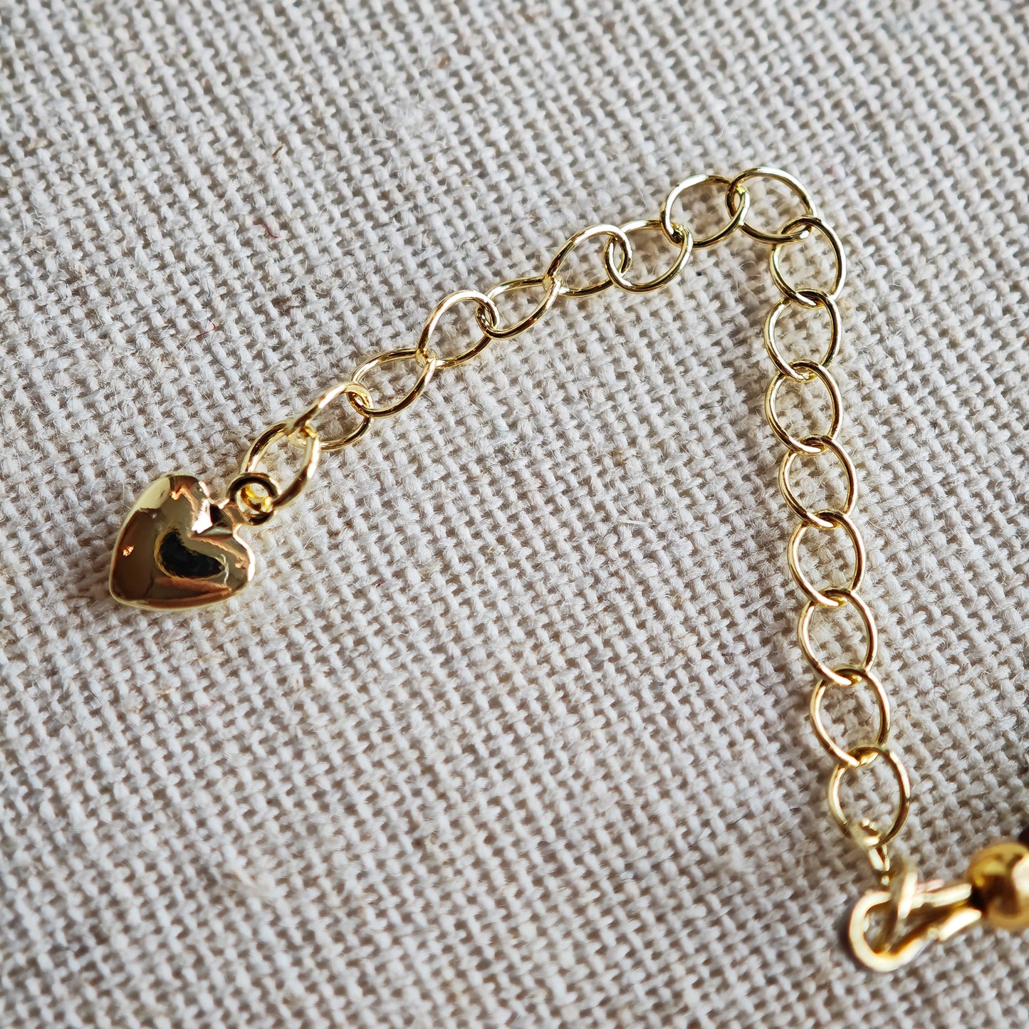 This vibrant bracelet features a colorful mix of ruby-red lemon, sapphire-blue flower, and emerald-green leaf charms, all dangling from a shimmering Czech glass bead chain.