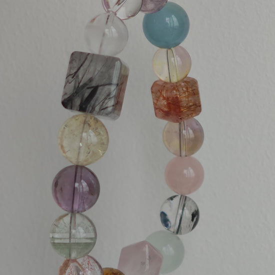 This multi gemstone bracelet features aquamarine, amethyst, strawberry quartz, rose quartz, green phantom quartz, and black rutilated quartz.