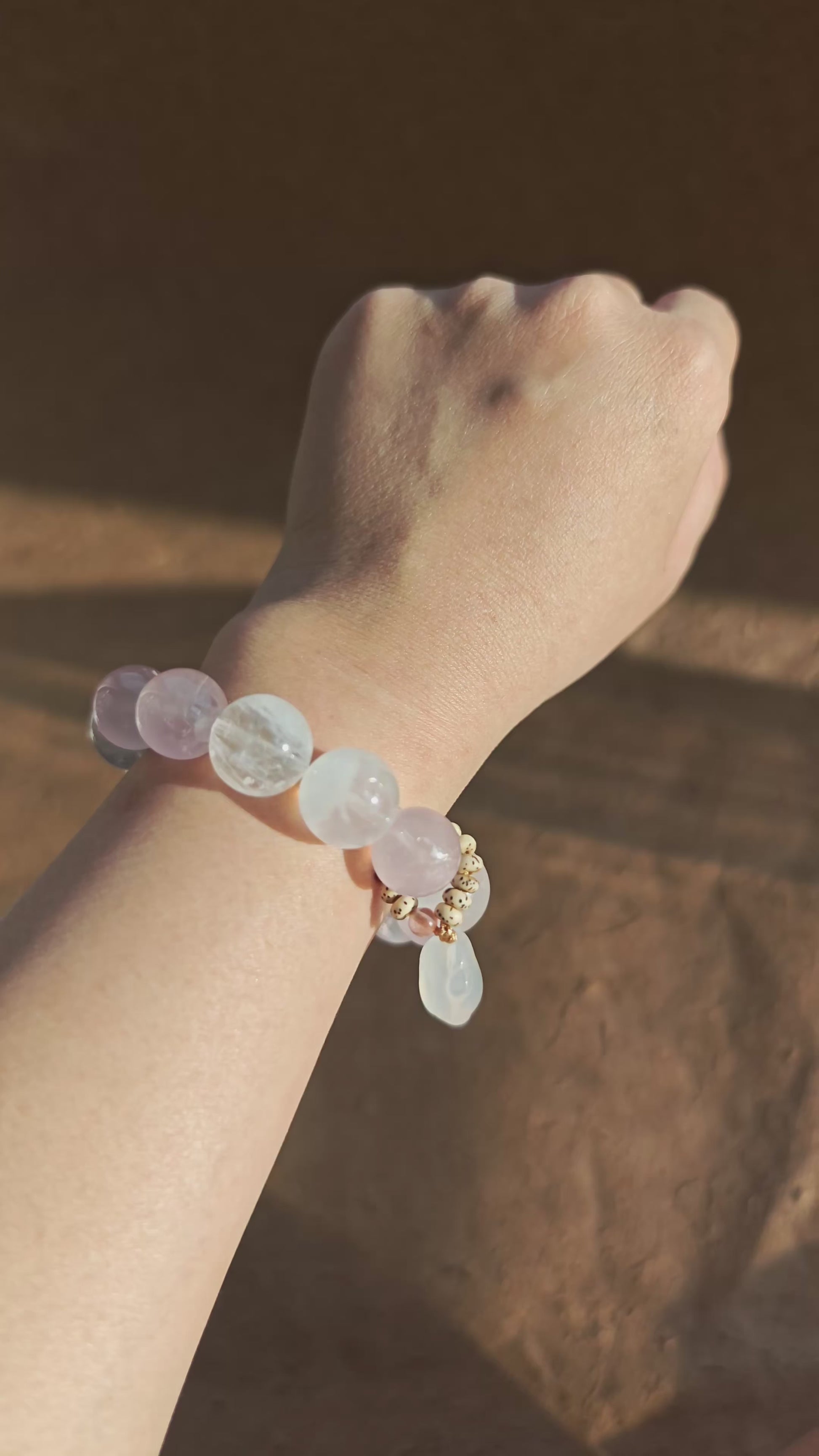 Hand-strung Rose Quartz, White Phantom Quartz, and an agate bunny slider make this crystal bracelet.