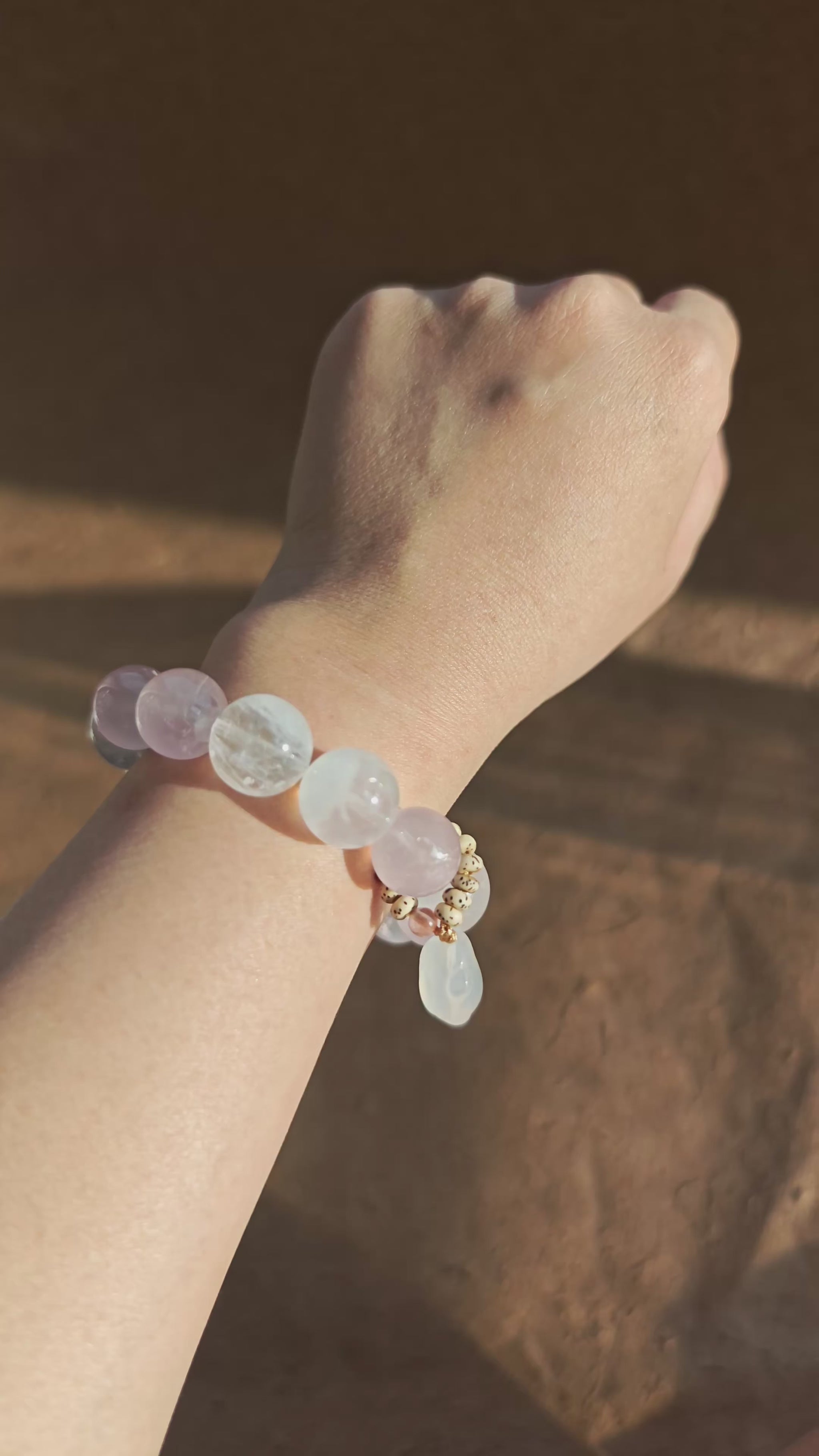 Hand-strung Rose Quartz, White Phantom Quartz, and an agate bunny slider make this crystal bracelet.