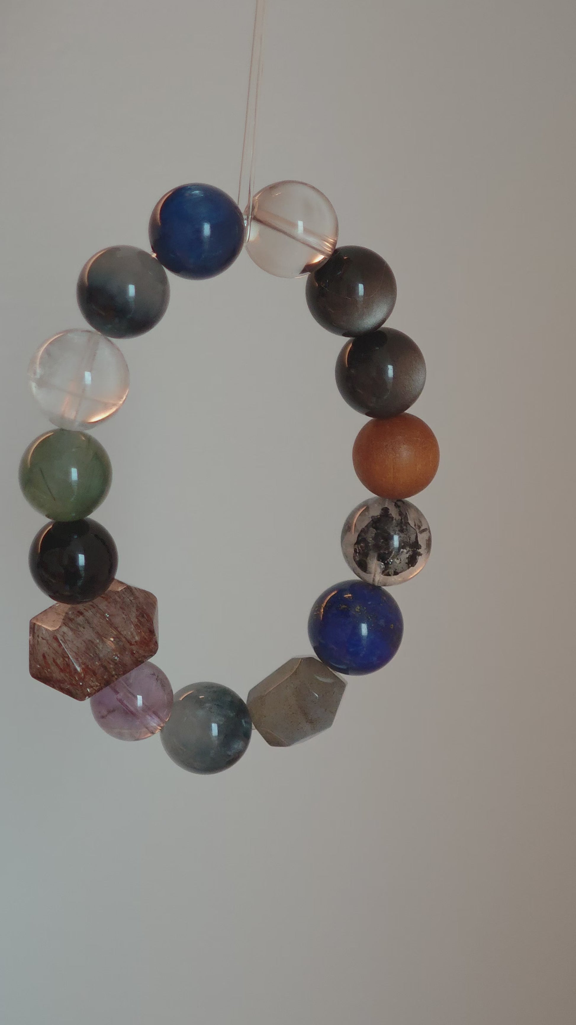 Cool lunar tones bloom from Black Gold Super Seven, Herkimer diamonds, clear quartz, sandalwood, amethyst, silver obsidian, white phantom quartz, and kyanite.